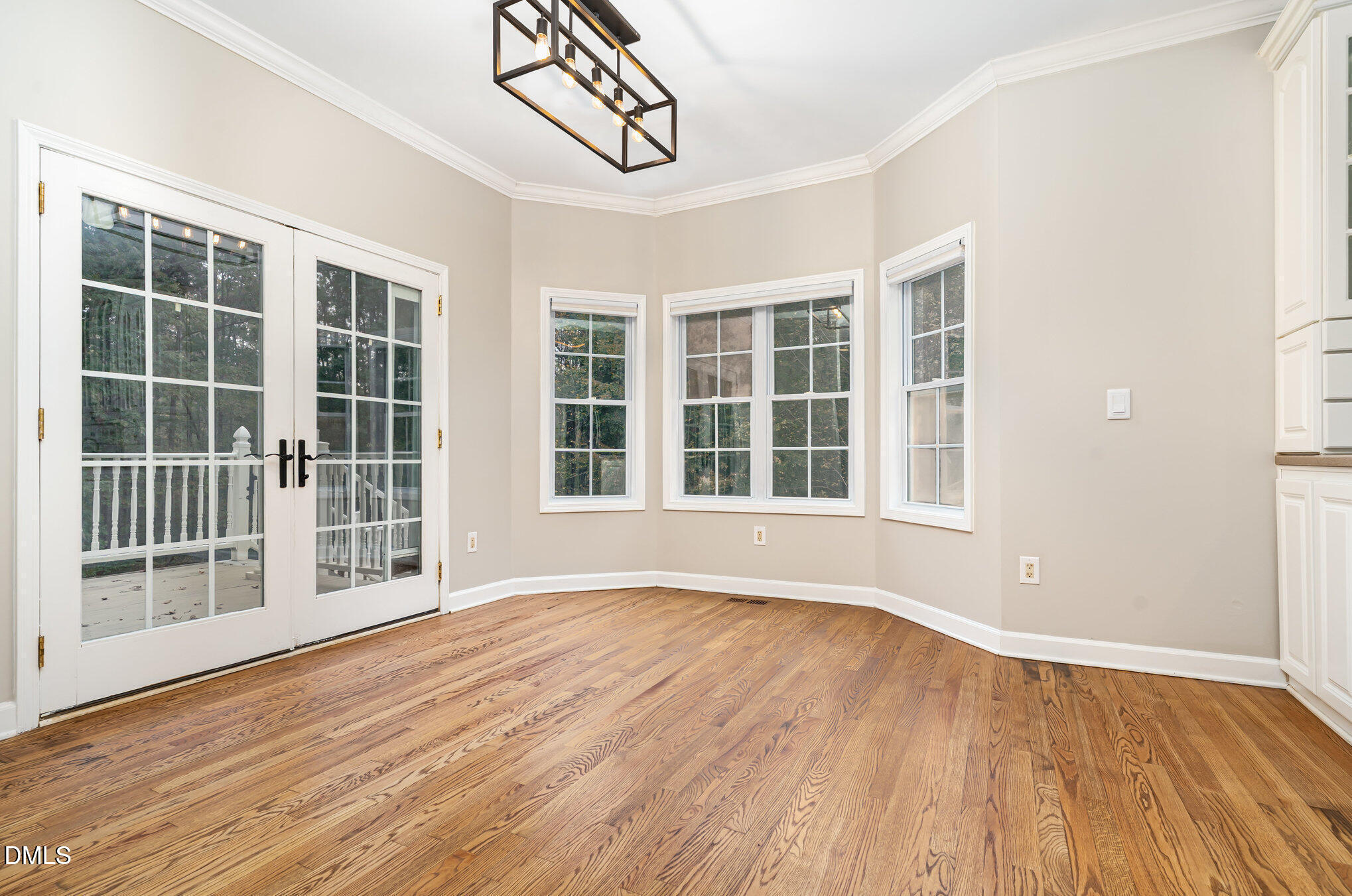 9036 Sundance Street Wake Forest, NC 27587 - Photo 5 of 22 a view of an empty room with wooden floor and windows