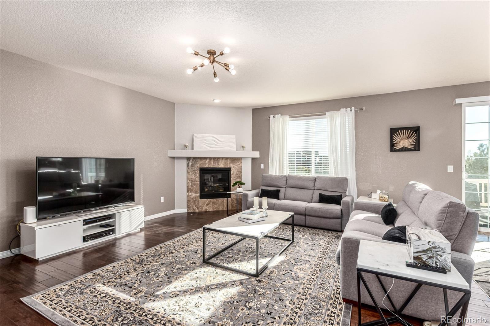 21074 East Doane Place Aurora, CO 80013 - Photo 8 of 44 a living room with furniture and a flat screen tv