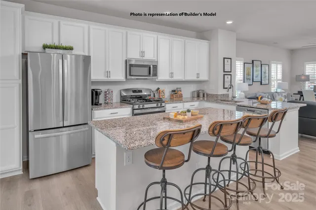 a kitchen with stainless steel appliances granite countertop a refrigerator and a stove top oven