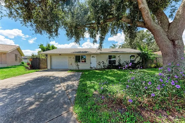 a view of a white house with a yard and potted plants