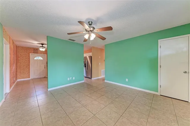 a view of an empty room with window and fan