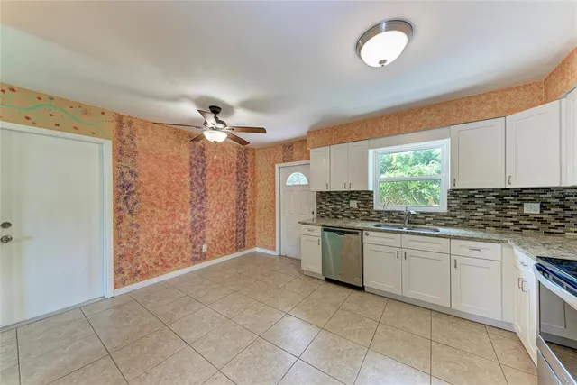 a kitchen with white cabinets and stainless steel appliances