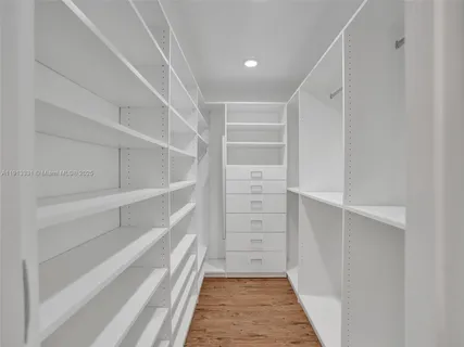 a view of walk in closet with empty racks