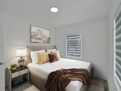 a bedroom with a bed and a painting on the wall