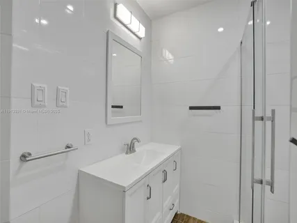 a bathroom with a sink a light fixture and a mirror