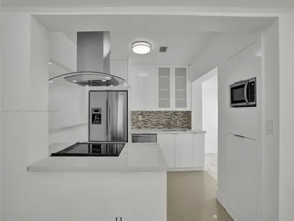 a kitchen with stainless steel appliances granite countertop a sink and a refrigerator