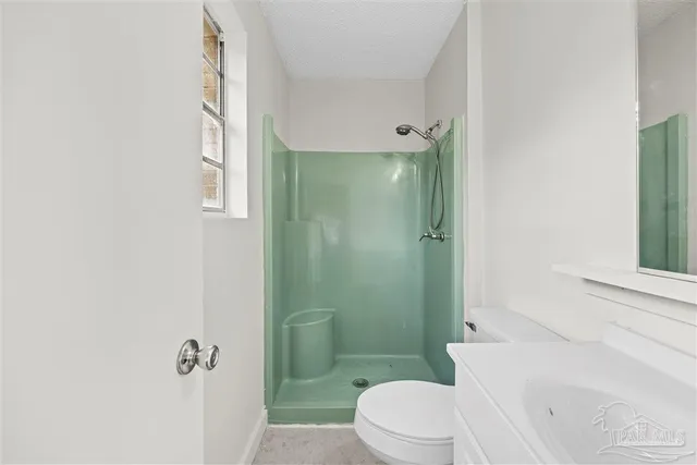 a bathroom with a toilet a sink and shower