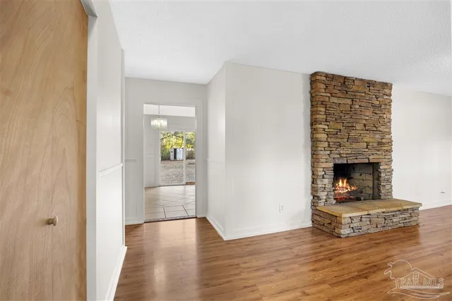 a view of an empty room and window with wooden floor