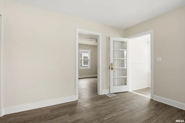 an empty room with wooden floor & windows and bathroom