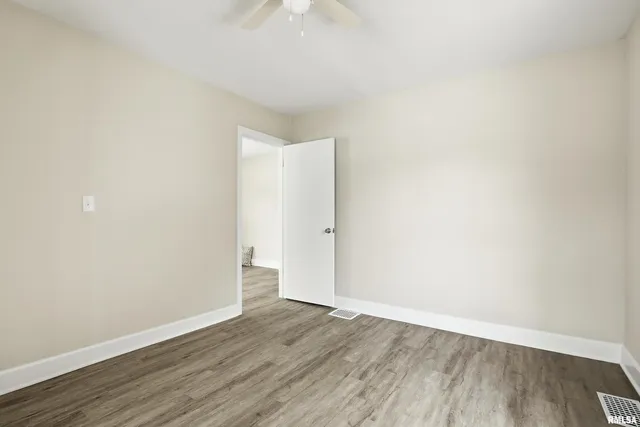 a view of an empty room with wooden floor