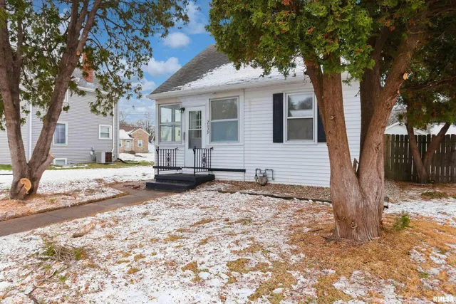 a front view of a house with a yard covered in snow