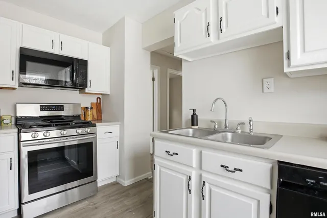 a kitchen with white cabinets stainless steel appliances and sink