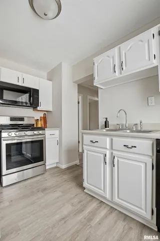 a kitchen with granite countertop a stove and a sink