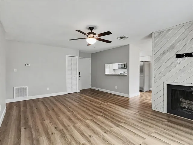 a view of empty room with wooden floor and fireplace
