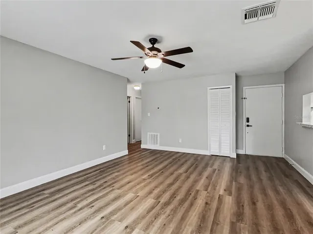 a view of an empty room with wooden floor