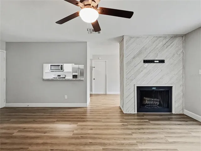 a view of a livingroom with a fireplace and wooden floor