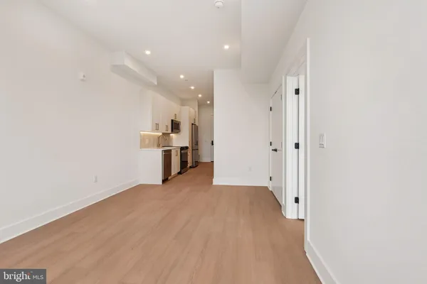 a view of a kitchen with wooden floor and electronic appliances