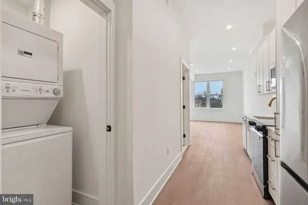 a view of a hallway with bathroom and wooden floor