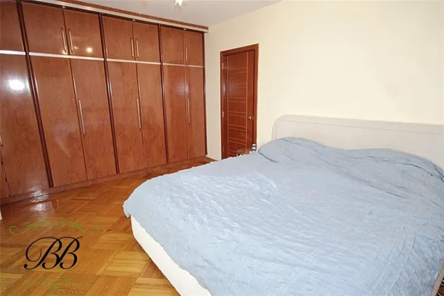 a bed sitting in a spacious bedroom next to a window