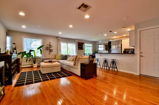 a living room with furniture and a wooden floor