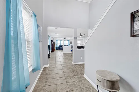 a view of a hallway with wooden floor and a living room