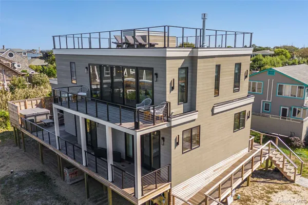 a view of a house with large windows and a small yard