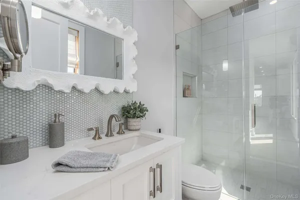 a bathroom with a granite countertop sink mirror and shower