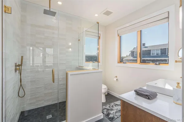 a bathroom with a granite countertop sink a shower and a mirror