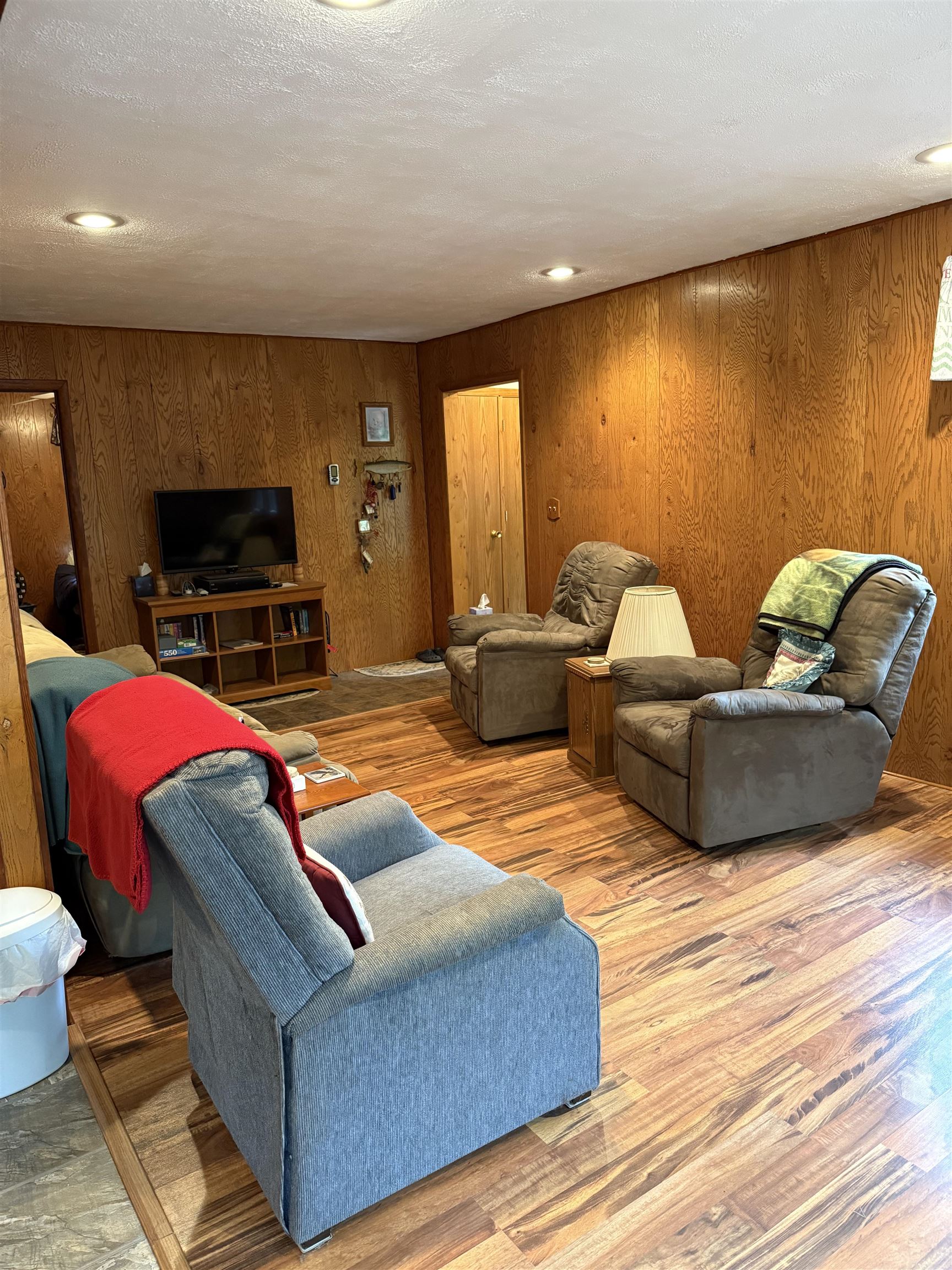 63380 Trout Lake Road Iron River, WI 54847 - Photo 13 of 36 Living area featuring wooden walls, wood finished floors, and a textured ceiling