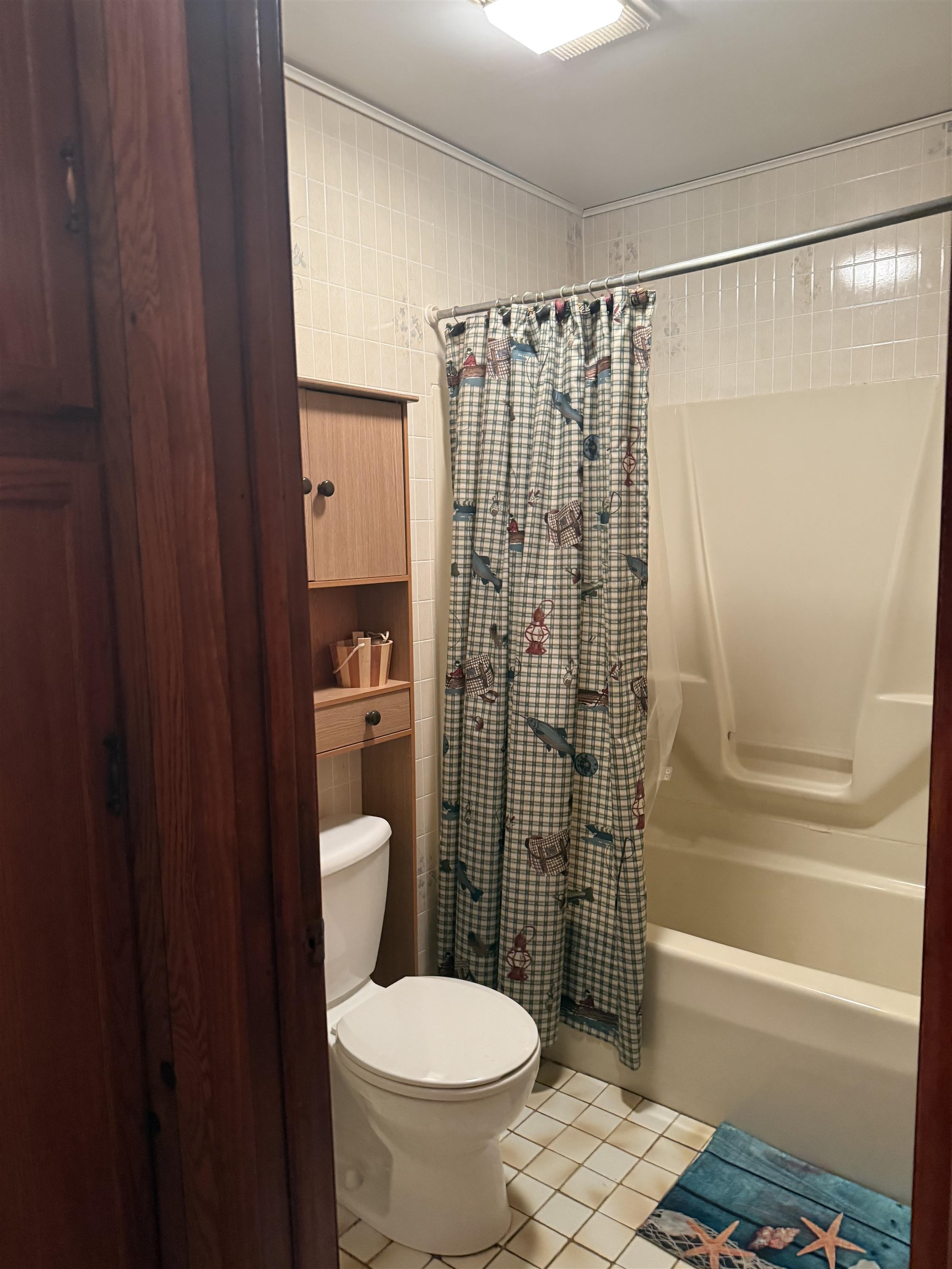 63380 Trout Lake Road Iron River, WI 54847 - Photo 29 of 36 Bathroom featuring light tile patterned floors, shower / tub combo with curtain, and tile walls