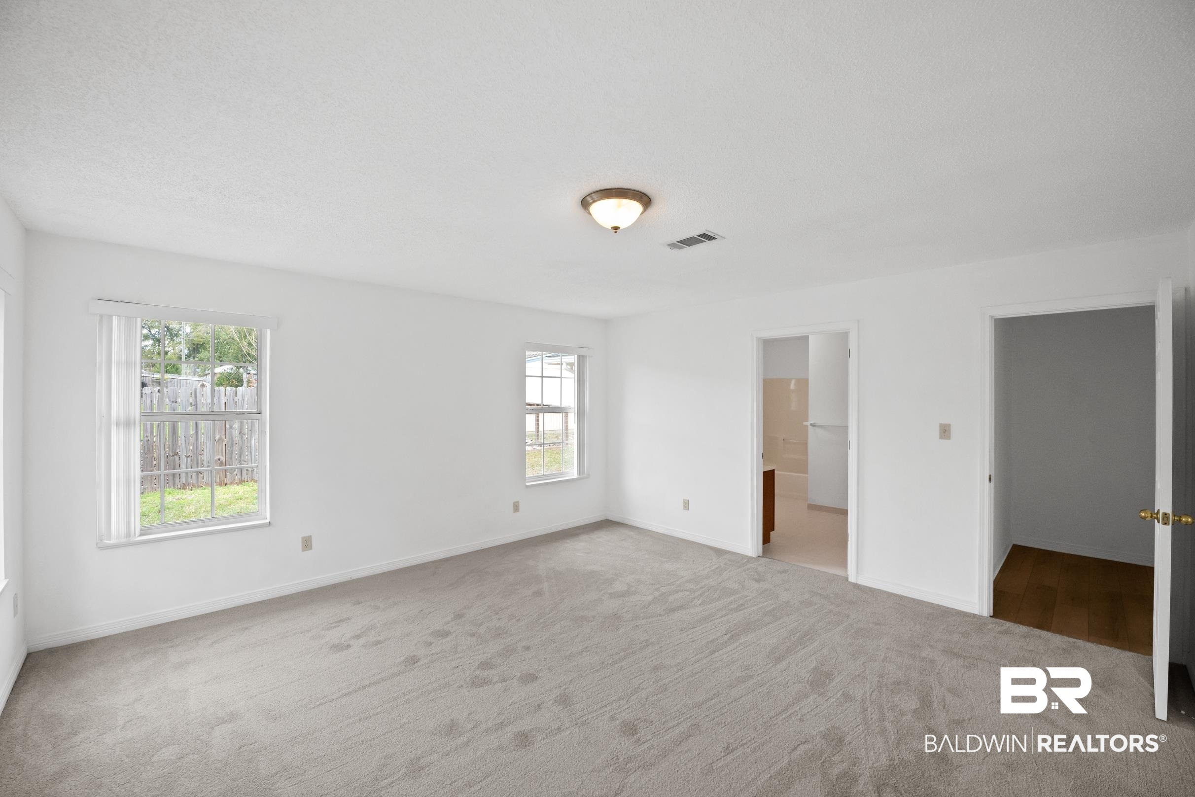 2673 Pine Ridge Drive Lillian, AL 36549 - Photo 14 of 38 Unfurnished bedroom with visible vents, multiple windows, baseboards, and carpet