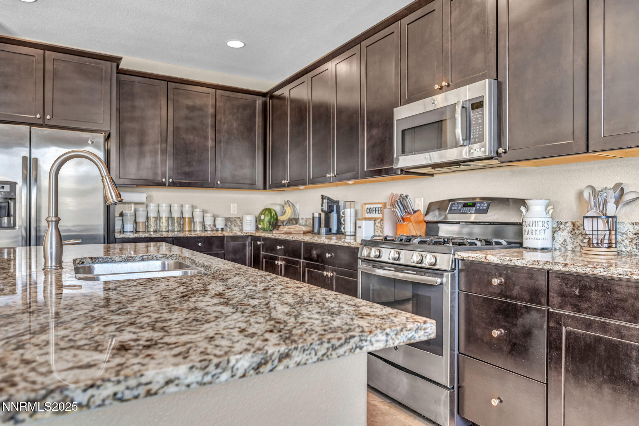 10305 Culiacan Pass Trail Reno, NV 89521 - Photo 50 of 93 a kitchen with stainless steel appliances granite countertop a stove top oven a sink dishwasher and white cabinets with wooden floor