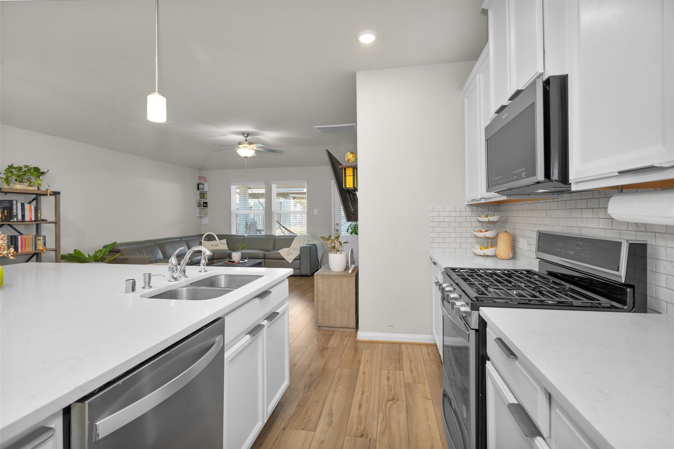 18544 Meadow Point Lane Montgomery, TX 77316 - Photo 16 of 35 a kitchen with a sink stove and microwave