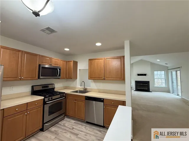 a kitchen with stainless steel appliances granite countertop a refrigerator a stove top oven a sink and dishwasher