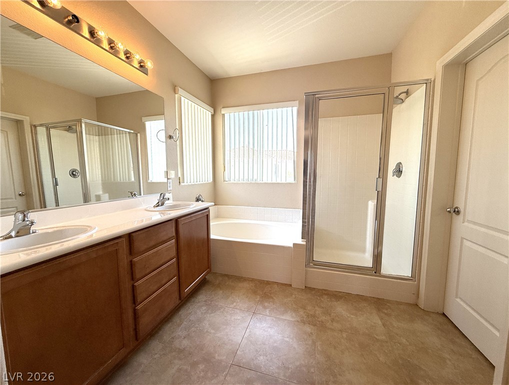 5942 Rampolla Drive Las Vegas, NV 89141 - Photo 16 of 27 Dual vanities and a spacious soaking tub provide a refreshing oasis in this primary bathroom.