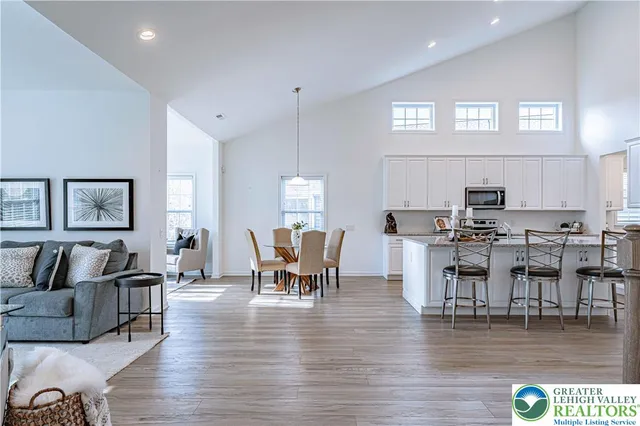 a dining room with furniture wooden floor and kitchen view