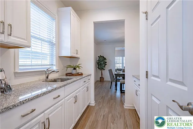 a kitchen with granite countertop a sink a counter space and wooden floor