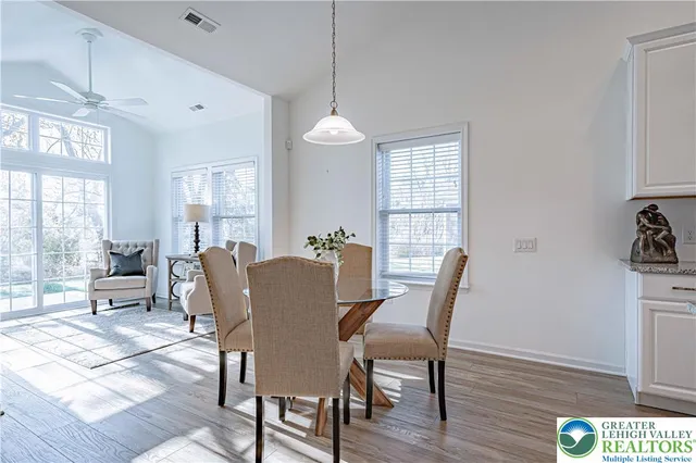 a dining room with furniture a chandelier and wooden floor
