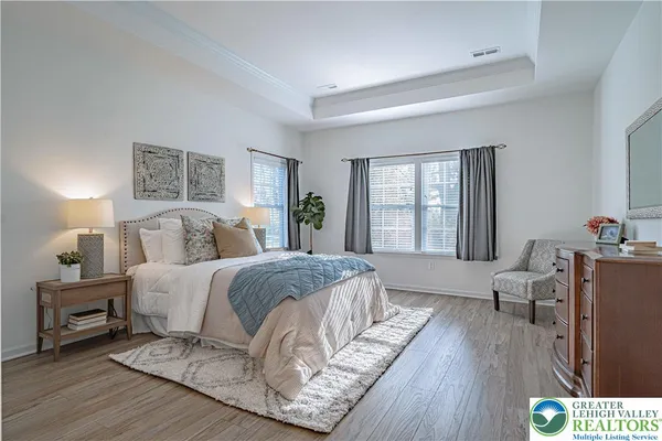 a spacious bedroom with a bed a couch and a large window