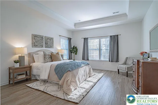 a spacious bedroom with a bed a couch and a large window