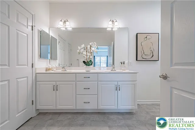 a bathroom with a sink vanity and mirror