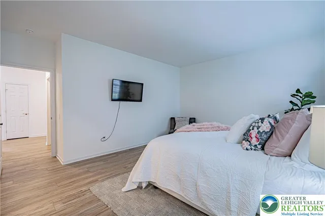 a bedroom with a bed and a wooden floor