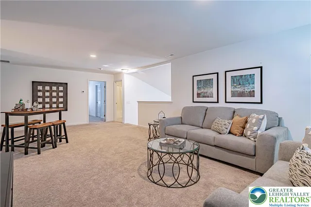 a living room with furniture a rug and a window