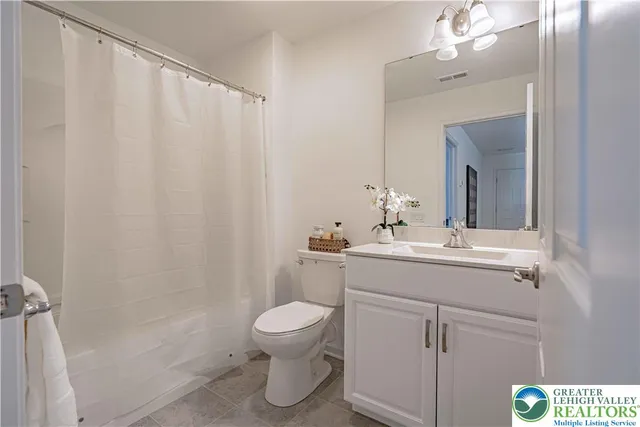 a bathroom with a sink a toilet and shower curtain