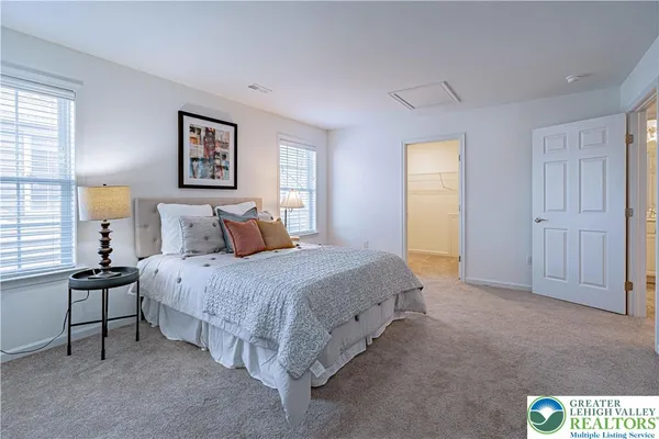 a spacious bedroom with a bed a table and chair