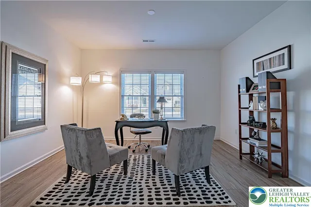 a view of a workspace with furniture and a window