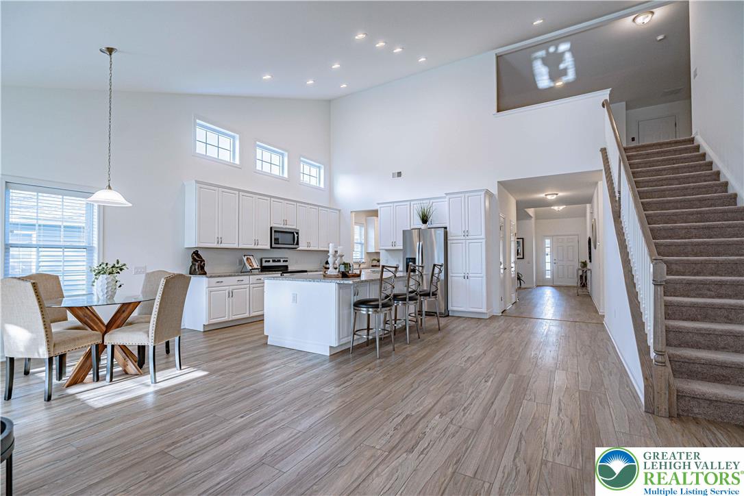 3855 Victors Way Easton, PA 18045 - Photo 10 of 47 a open kitchen with stainless steel appliances kitchen island granite countertop a table chairs and a refrigerator