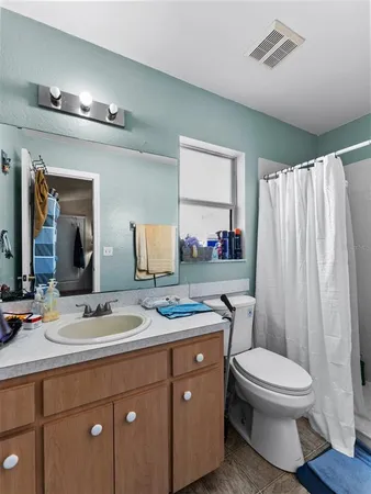 a bathroom with a toilet a sink and a mirror