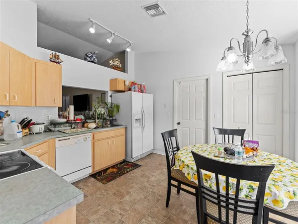 a kitchen with a dining table chairs and refrigerator