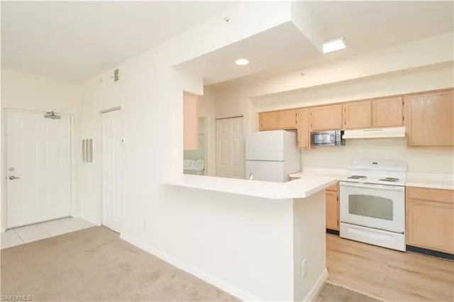 a kitchen with a refrigerator sink and cabinets